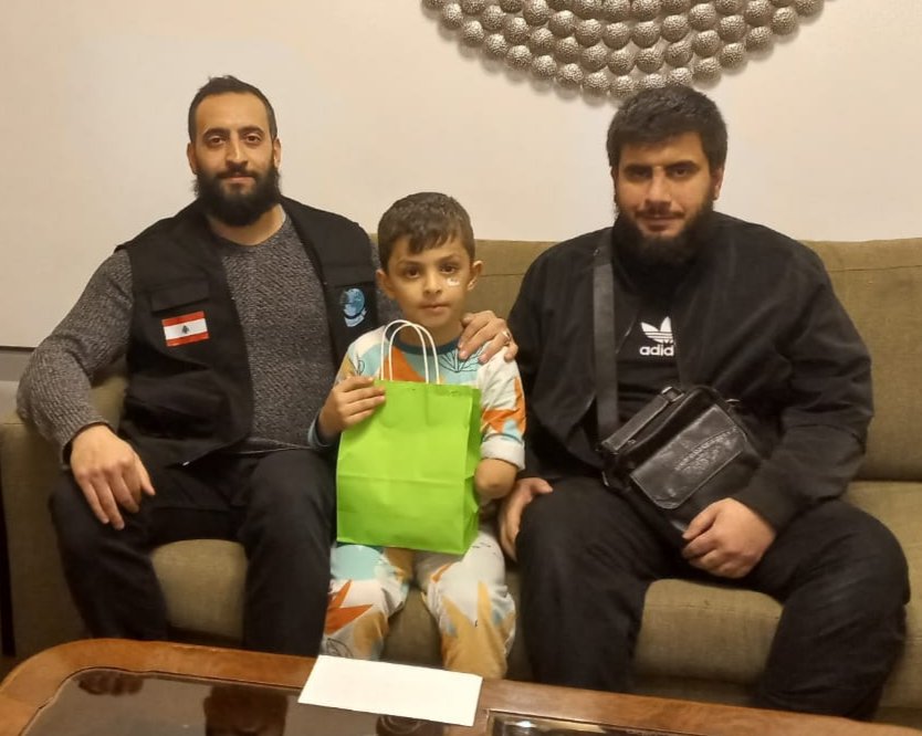 متطوّعو آفاق الخير مع طفلٍ جريح من غزة يحمل هديّته