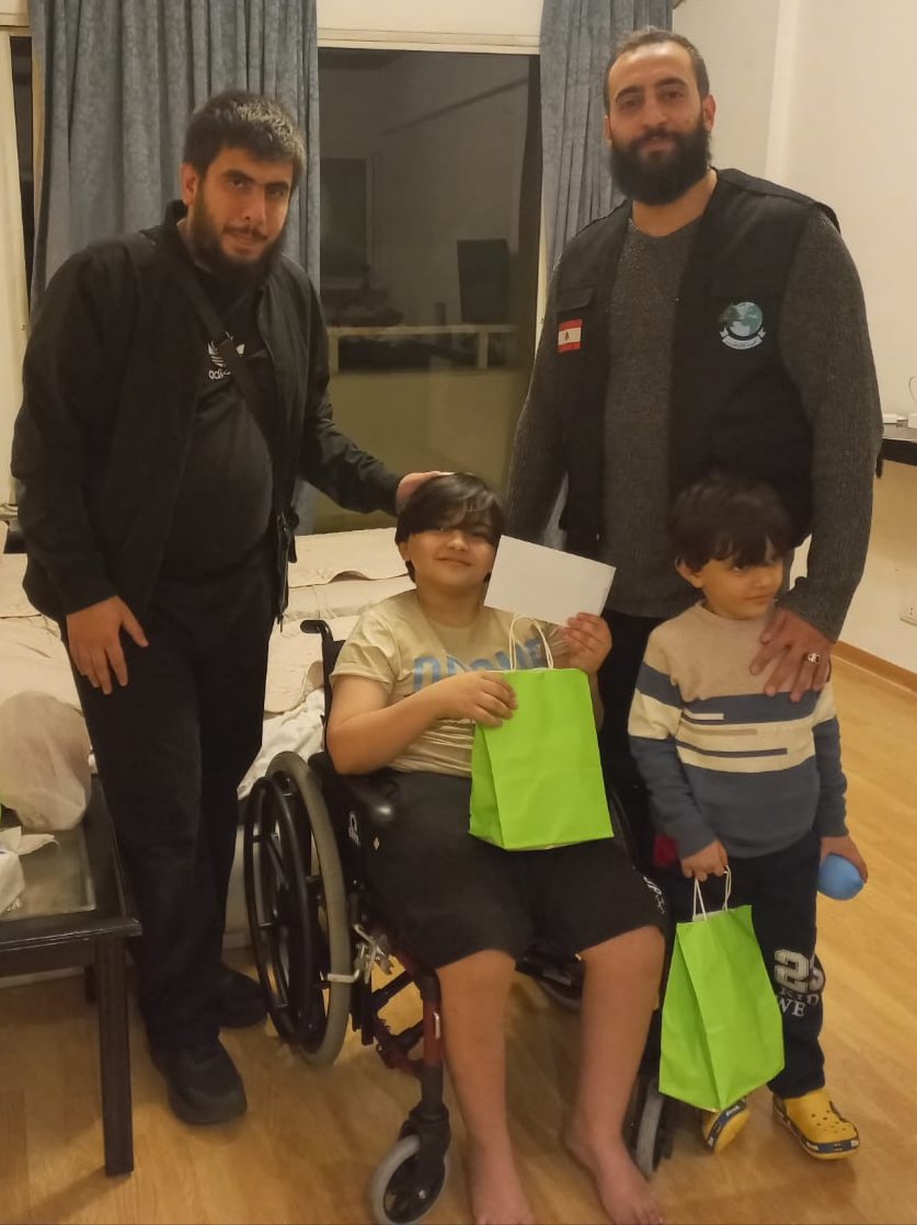 طفلٌ على كرسيّ متحرّك يتلقّى هديّته خلال الزيارة